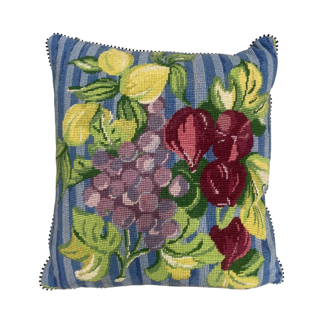 a beautiful hand made tapestry cushion depicting a bunch of grapes and figs with lovely lime green and yellow leaves.
